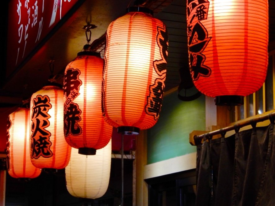 Illuminated street scene in Shinjuku with izakaya signs