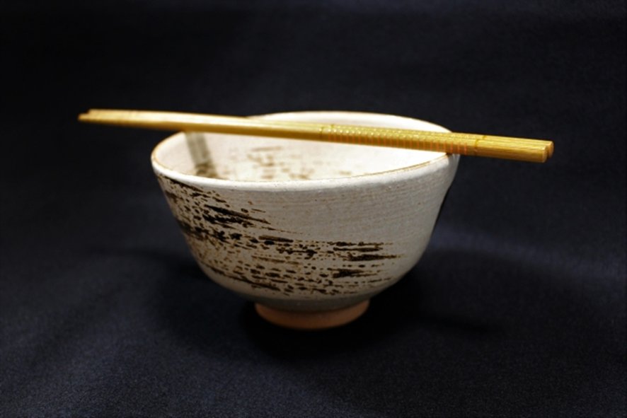 Chopsticks resting across bowl watashi-bashi taboo