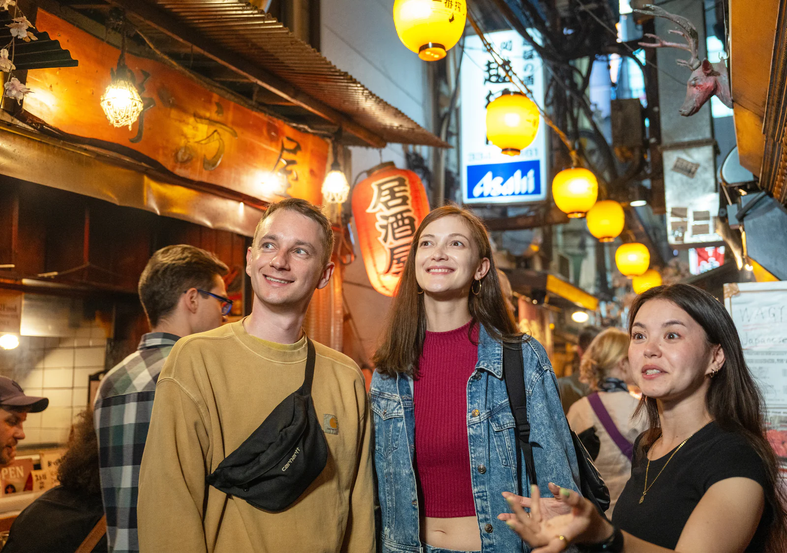 Glowing lanterns and lively bar scene at night in a Japanese alleyway