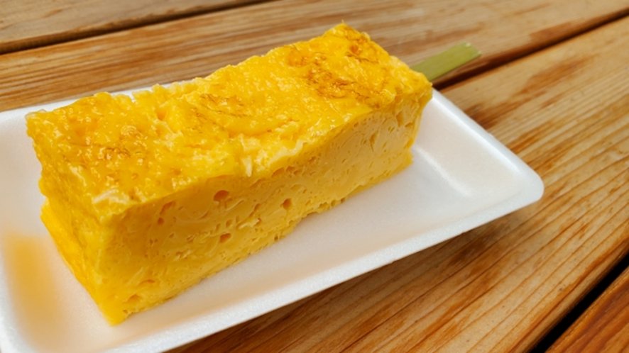 Golden tamagoyaki rolled omelette on bamboo skewer